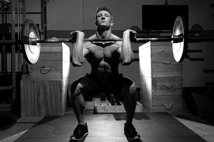 een man die een front squat-oefening doet