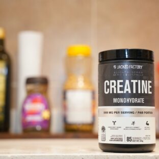 A container labeled creatine monohydrate on a kitchen counter.