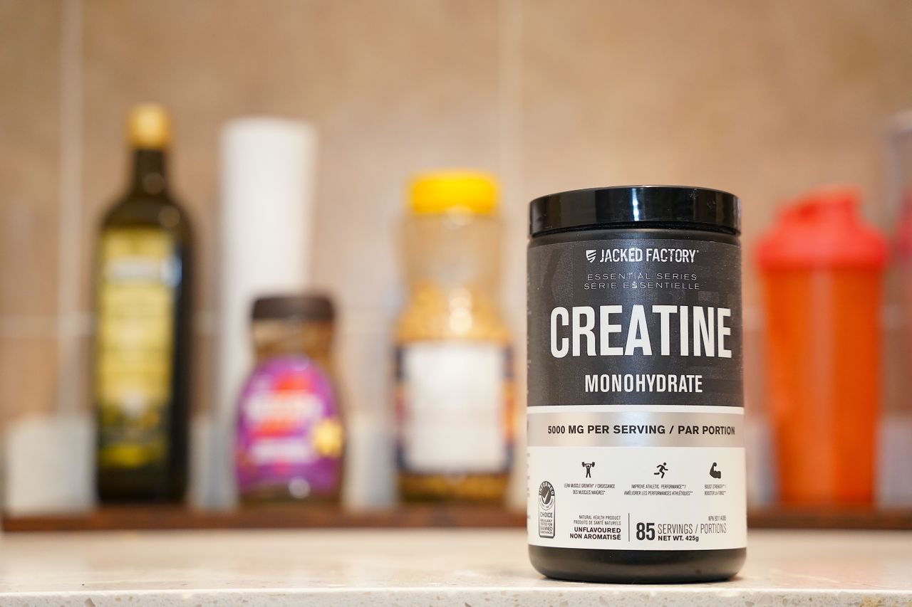 A container labeled creatine monohydrate on a kitchen counter.